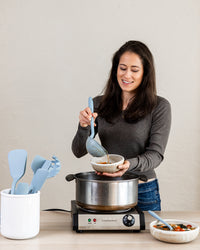 A woman using the GIR 10 Piece Chef Set in a kitchen setting.