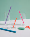 GIR Straws of different colors and sizes in empty glasses.