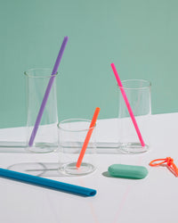 GIR Straws of different colors and sizes in empty glasses.