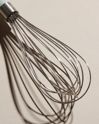 Close up of the Whisk head on a cream background.