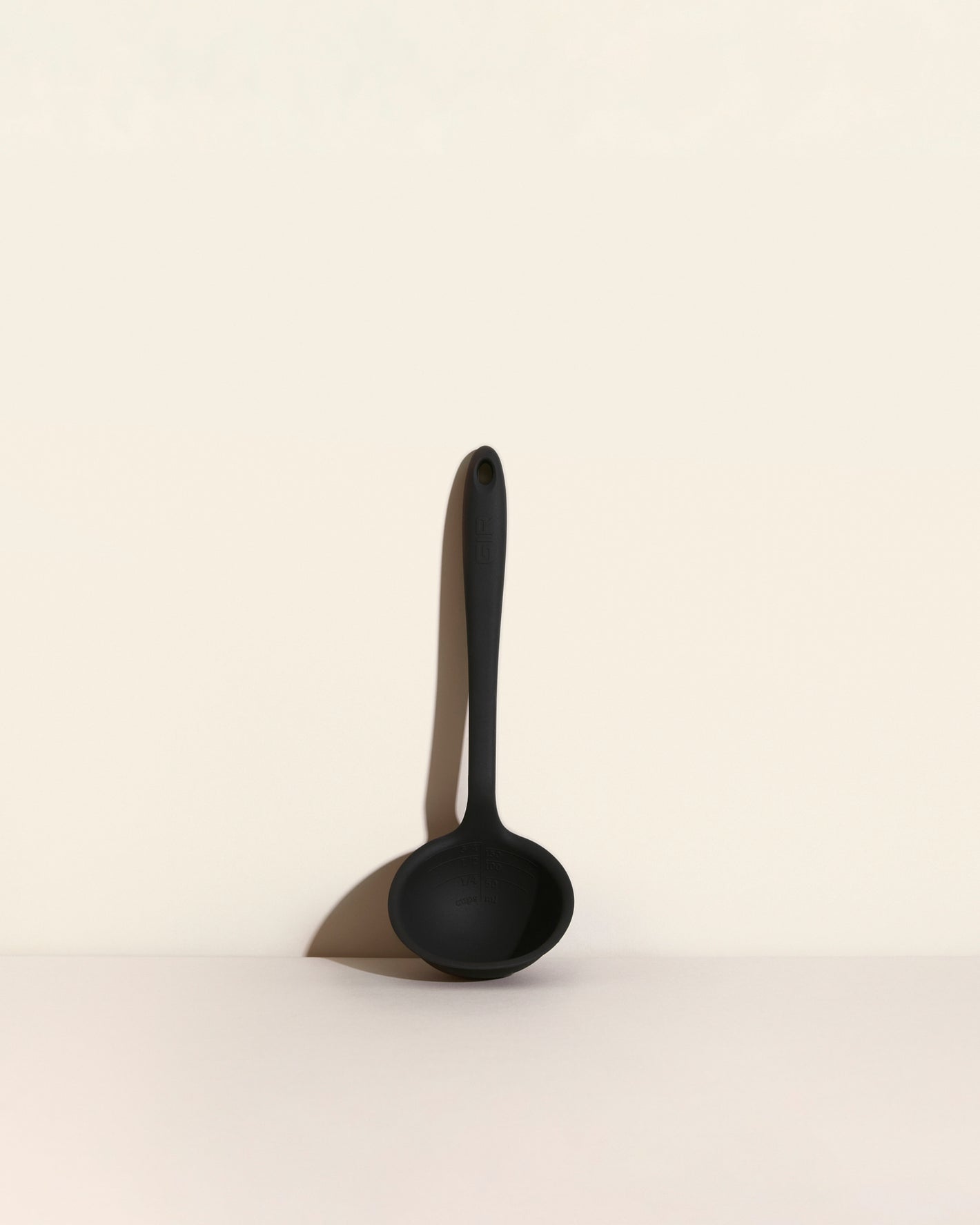 The Black Ultimate Ladle on a cream background.