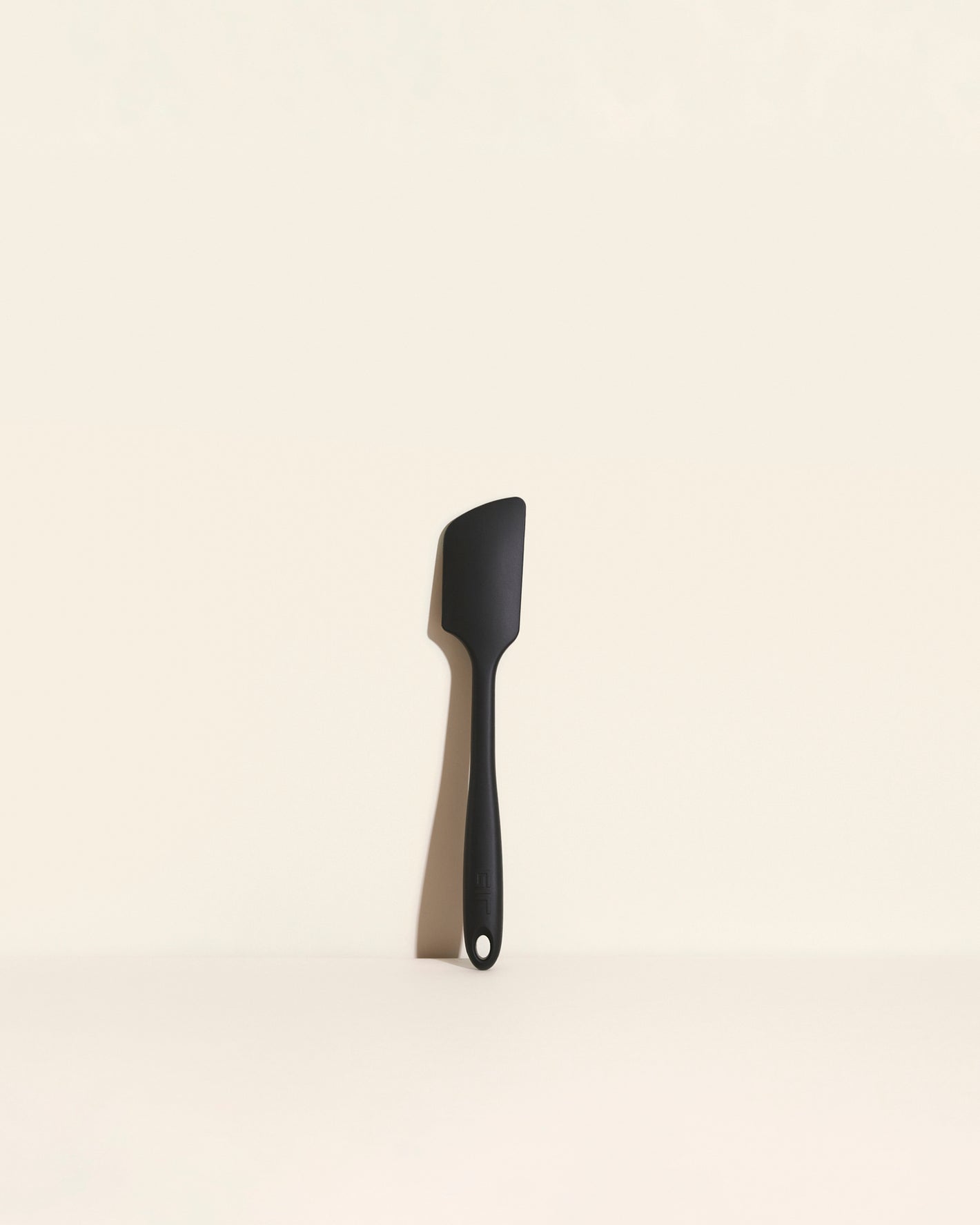 The GIR Black Ultimate Spatula on a cream background. 