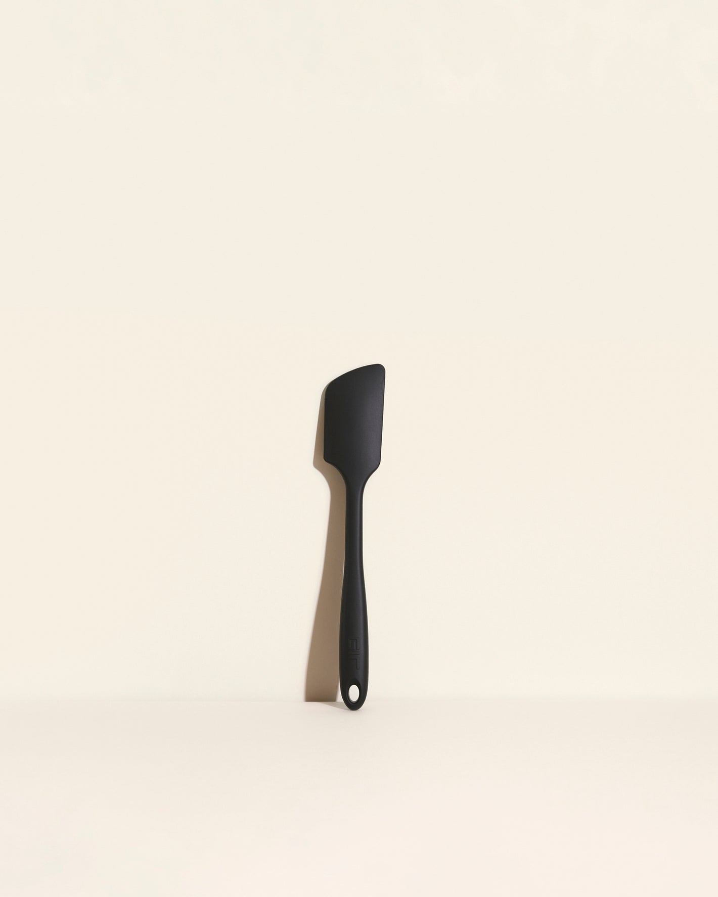 The GIR Black Ultimate Spatula on a cream background.