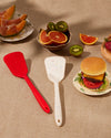 The GIR Ultimate Turner in Red and Sprinkle next to each other on a table with food and fruits around it.