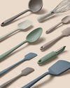 Set of kitchen utensils including spatulas, ladle, and whisk on a beige background