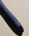 Close up of the handle of the GIR Navy Ultimate Flip on a cream background. 