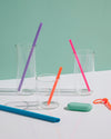 GIR Straws of different colors and sizes in empty glasses. 