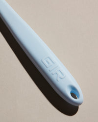 Close up of the handle of the GIR Light Blue tool on a cream background. 
