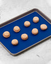 The Standard Quarter Royal Blue Baking Mat with Peach Macaroons on it. 
