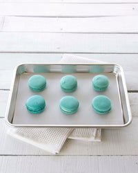 The Half Sheet Studio Baking Mat with Teal Macaroons on it. 