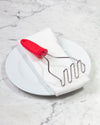 The GIR Wired Masher on a white towel and plate. 