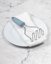 The GIR Wired Masher in Slate on a white towel and plate. 