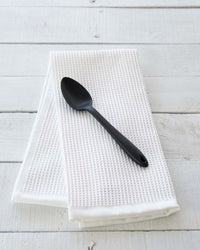 The Black Mini Spoon on a White towel. 