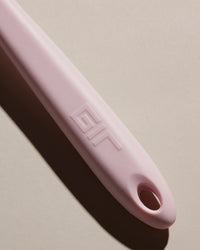 Close up of the GIR Light Pink Ultimate Spatula on a cream background. 