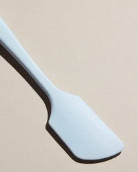 Close up of the Light Blue Spatula on a cream background. 