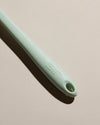 Close up of the Handle of the Mint Ultimate Spoonula on a cream background. 