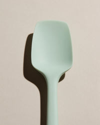 A close up of the Mint Spoonula on a cream background. 