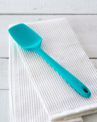 The Teal Ultimate Spoonula on an Onsen Towel on a white background. 