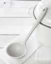 The Studio Ultimate Ladle resting on a white towel on a white background. 
