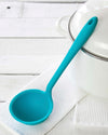 The Teal Ultimate Ladle on a white towel on a white background.  