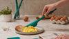 A hand placing eggs on a plate with the GIR spatula.