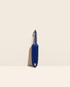  The I Handle Serrated Peeler in Navy on a cream background. 