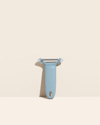  The Y Handle Flat Peeler in Slate on a cream background. 