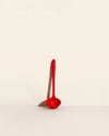 The Red Skinny Ladle on a cream background. 