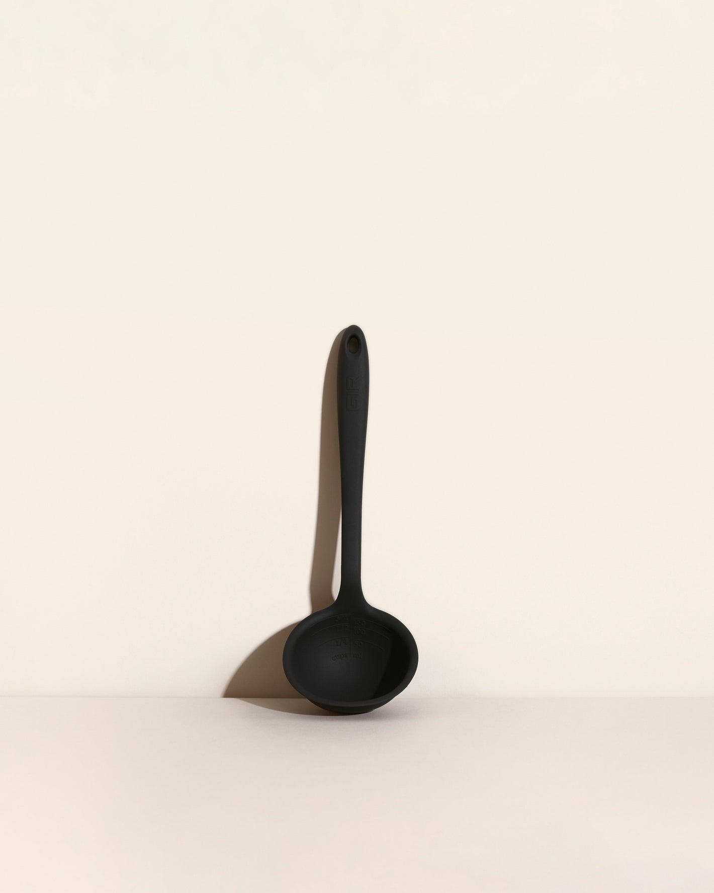 The Black Ultimate Ladle on a cream background. 