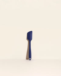 The Navy Ultimate Spatula on a cream background. 