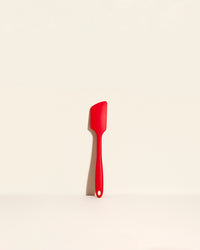 The Red Ultimate Spatula on a cream background. 