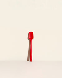 The Red Skinny Spatula on a cream background. 