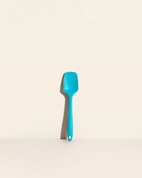 The Teal Ultimate Spoonula on a cream background. 
