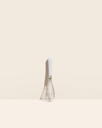 The Studio Mini Whisk on a cream background. 
