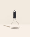 The GIR Perforated Masher in Black on a cream background. 