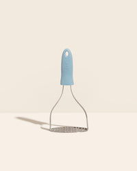 The GIR Slate Perforated Masher on a cream background. 