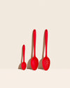 The 3 Piece Red Spoon Set on a cream background. 
