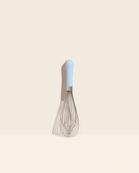 The Light Blue Ultimate Whisk on a cream background. 