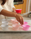 A lady placing the Strawberry Swirl Cupcake Liners on a baking tray. 