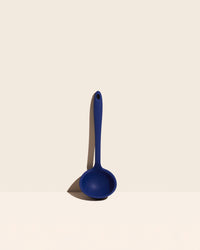 The Navy Ultimate Ladle on a cream background. 