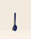 The Navy Perforated Spoon on a cream background. 