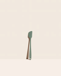 The GIR Sage Green Skinny Spatula on a pink background.