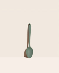 The GIR Sage Green Ultimate Spoon on a pink background.