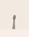 The GIR Sage Green Skinny Spoonula on a pink background.