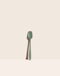 The GIR Sage Green Skinny Spoonula on a pink background.